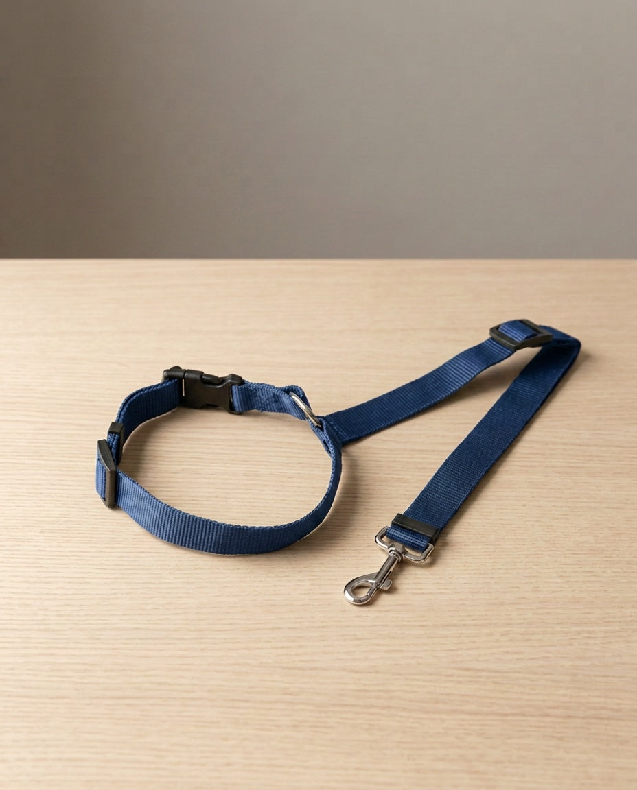Cinturón de seguridad 2 en 1 para perro en azul marino, extendido sobre madera clara