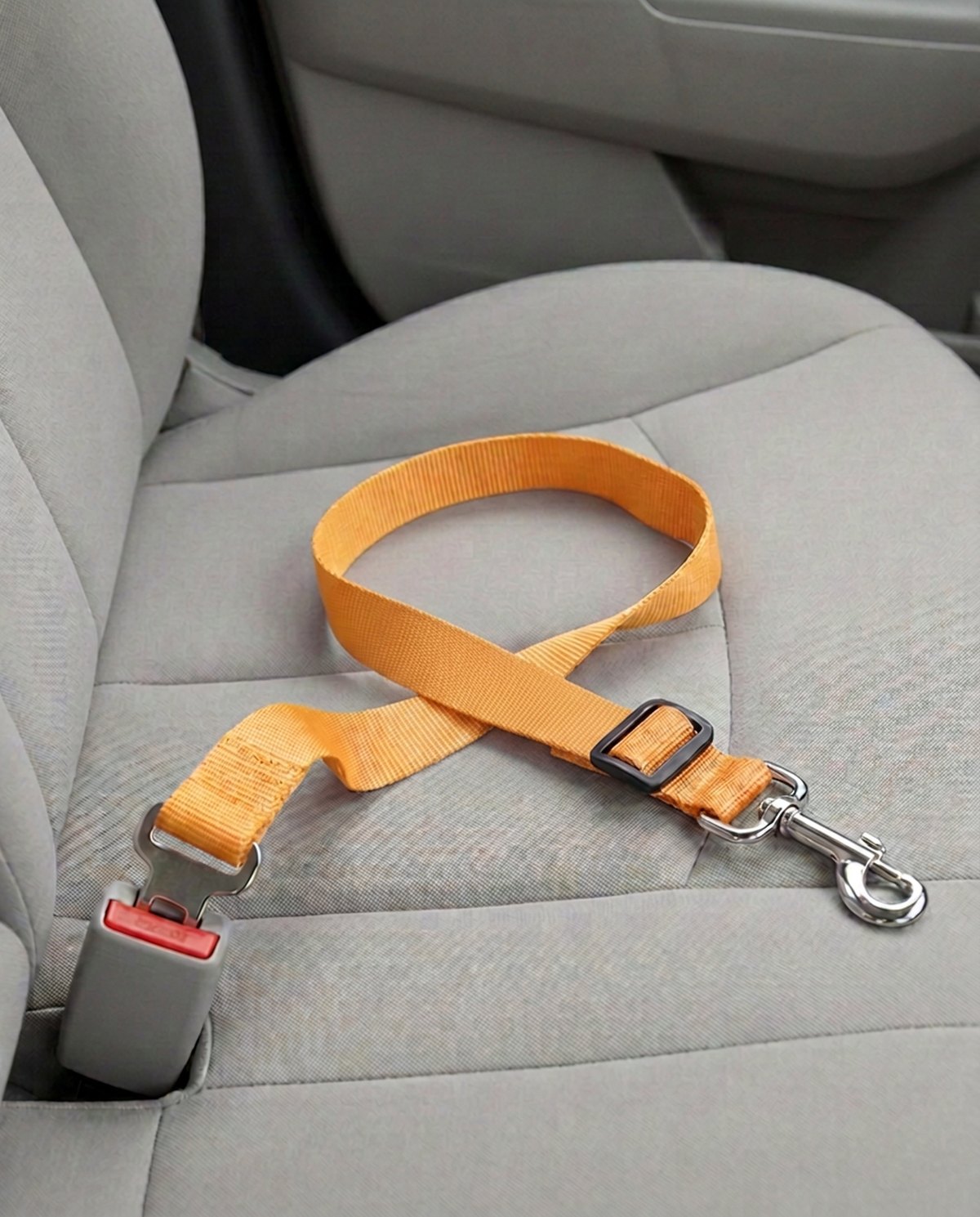 Cinturón de seguridad para coche en amarillo, abrochado a la hebilla del asiento del copiloto
