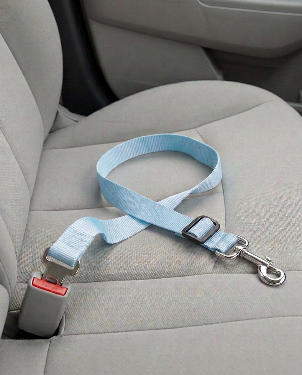 Cinturón de seguridad para coche en azul celeste, abrochado a la hebilla del asiento del copiloto