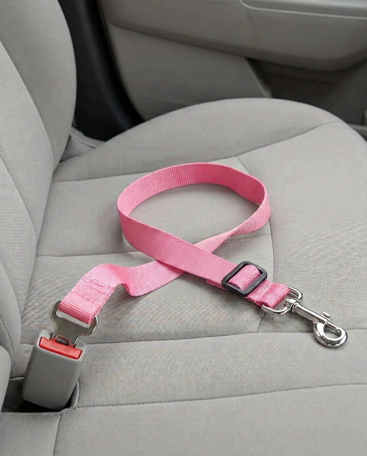 Cinturón de seguridad para coche en rosa, abrochado a la hebilla del asiento del copiloto